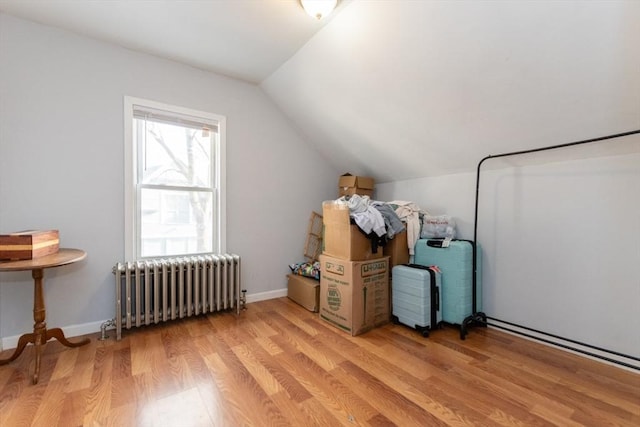 bonus room featuring light wood-style floors, lofted ceiling, radiator, and baseboards