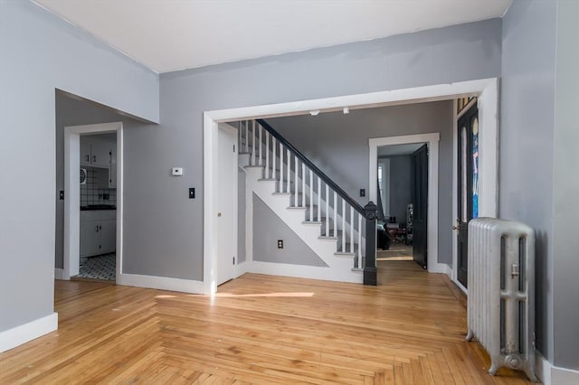 foyer entrance featuring radiator and parquet floors