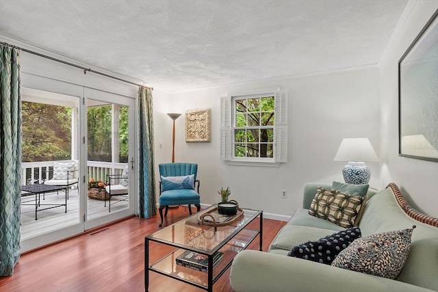 living room featuring healthy amount of natural light, wood finished floors, and baseboards