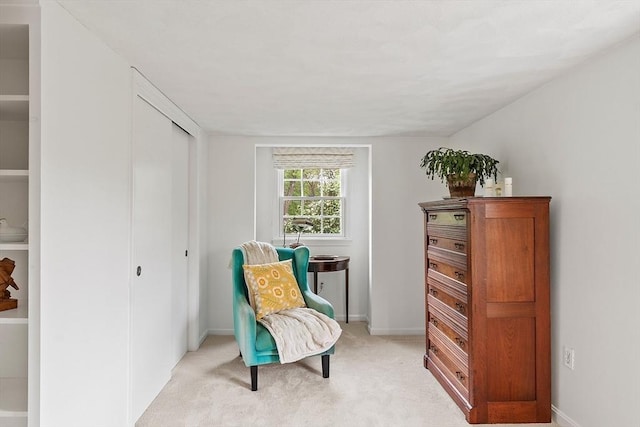 living area with light carpet and baseboards