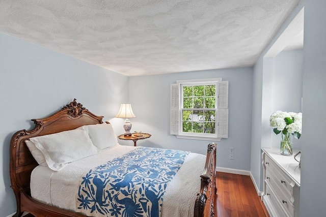 bedroom featuring dark wood-type flooring, baseboards, and a textured ceiling