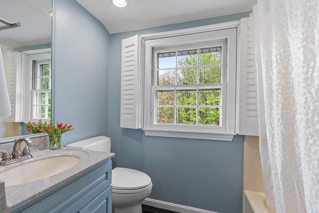 bathroom featuring toilet, baseboards, and vanity