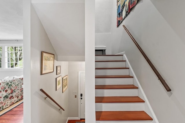 stairs featuring vaulted ceiling and wood finished floors