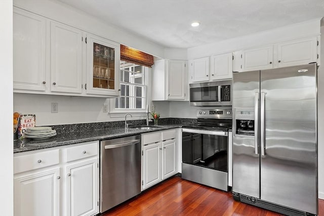 kitchen featuring appliances with stainless steel finishes, a sink, white cabinetry, dark wood finished floors, and recessed lighting