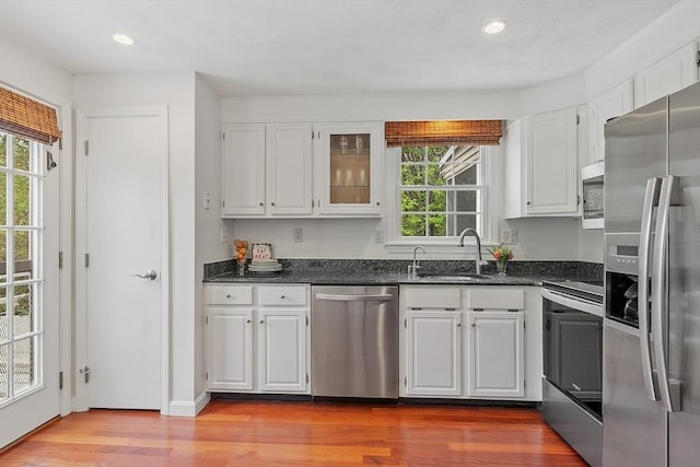 kitchen with stainless steel appliances, a sink, plenty of natural light, white cabinets, and recessed lighting