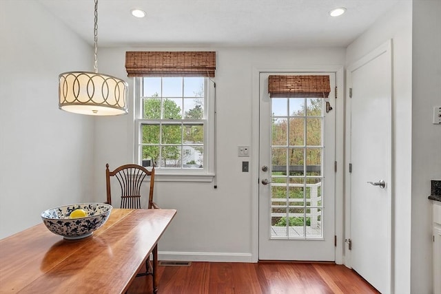doorway to outside with plenty of natural light, wood finished floors, recessed lighting, and baseboards