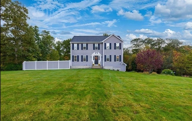 colonial-style house featuring a front yard