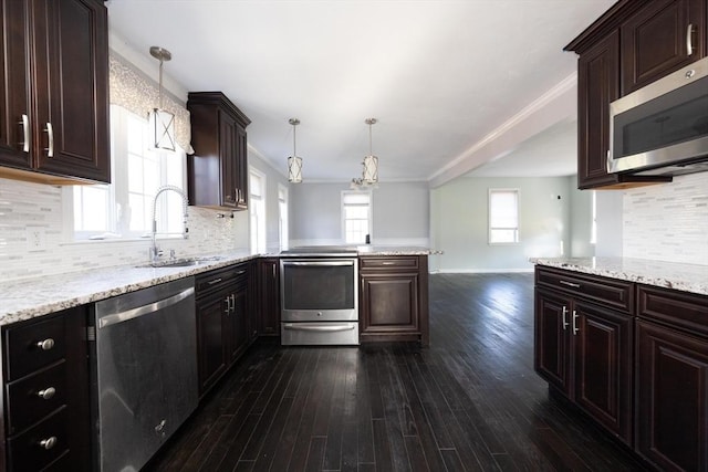 kitchen with sink, dark wood-type flooring, tasteful backsplash, decorative light fixtures, and appliances with stainless steel finishes