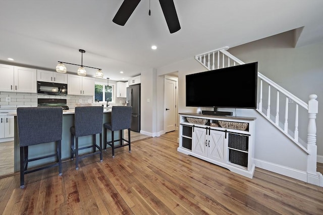 45 Weyham Rd, Weymouth, MA 02191 - kitchen with black appliances, ceiling fan, backsplash, white cabinetry, and wood finished floors