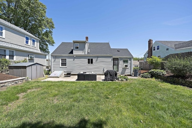 45 Weyham Rd, Weymouth, MA 02191 - back of property featuring a patio area, a chimney, and a shingled roof