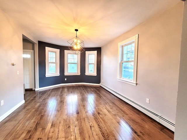 unfurnished room with baseboard heating, a chandelier, and wood-type flooring