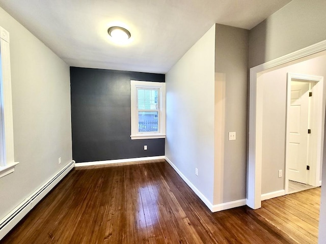 spare room featuring dark hardwood / wood-style floors and a baseboard heating unit