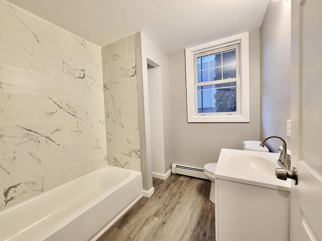 full bathroom with vanity, wood-type flooring, a baseboard radiator, toilet, and tiled shower / bath