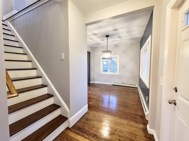 foyer entrance with dark hardwood / wood-style floors, an inviting chandelier, and a baseboard heating unit