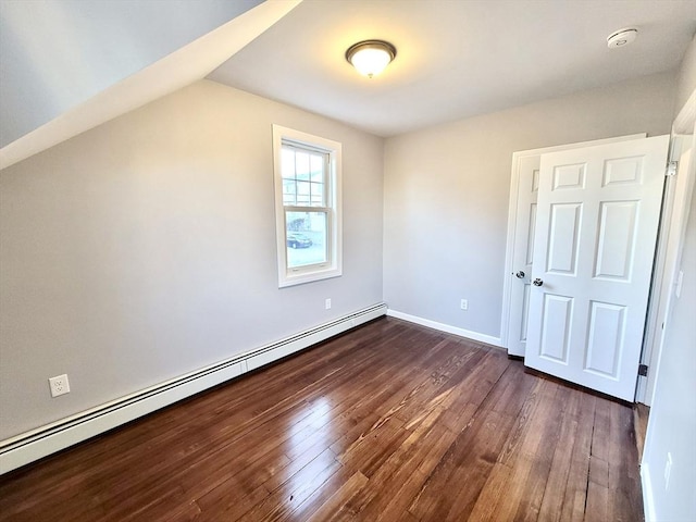 additional living space featuring dark hardwood / wood-style flooring, a baseboard radiator, and vaulted ceiling