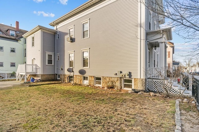 rear view of house with a lawn and cooling unit