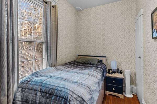 bedroom with dark hardwood / wood-style flooring