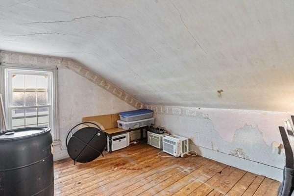 additional living space with light hardwood / wood-style flooring and vaulted ceiling