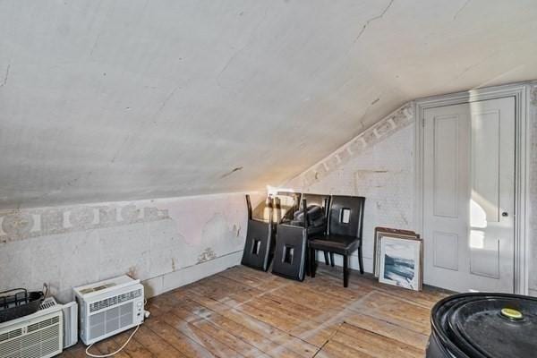 additional living space with vaulted ceiling and hardwood / wood-style flooring