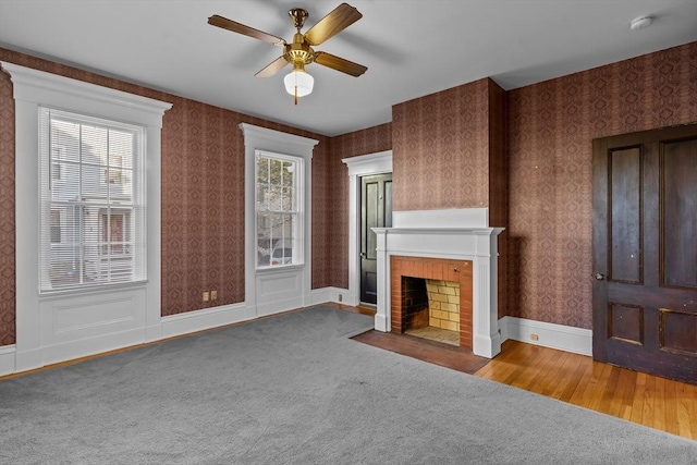 unfurnished living room with a fireplace, carpet floors, and ceiling fan