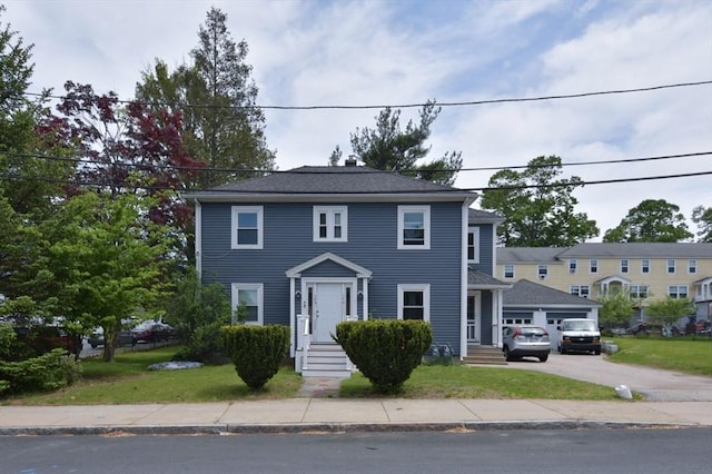 view of front of home with driveway, a front lawn, and a garage