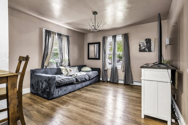 living room with a chandelier, wood finished floors, and baseboards