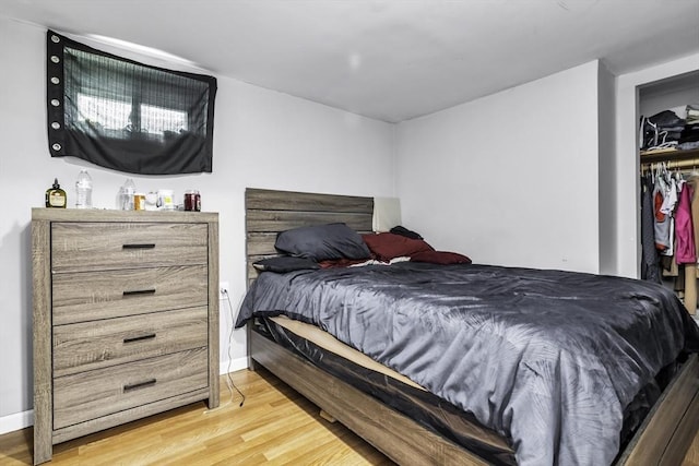 bedroom featuring light wood finished floors and baseboards
