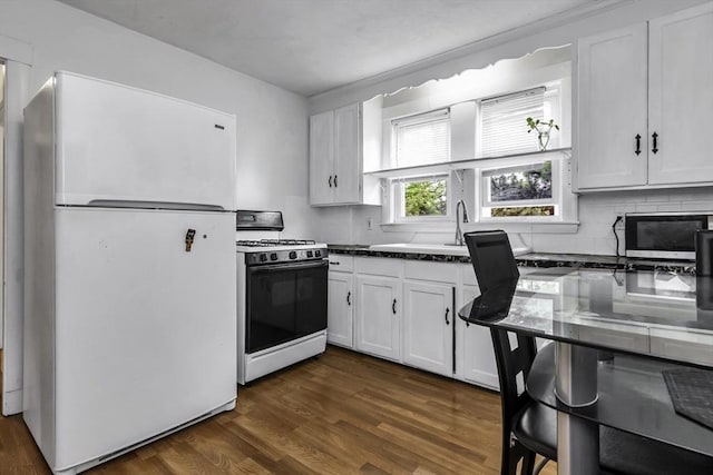 kitchen featuring white appliances, white cabinetry, dark wood finished floors, dark countertops, and tasteful backsplash