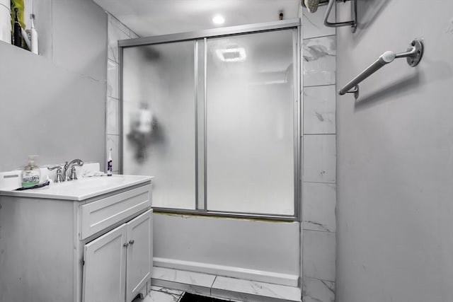 bathroom featuring marble look tile flooring, vanity, and shower / bath combination with glass door