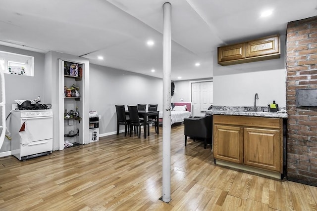 indoor wet bar with white gas stove, light wood-style floors, and recessed lighting