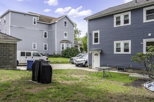 rear view of property featuring a yard