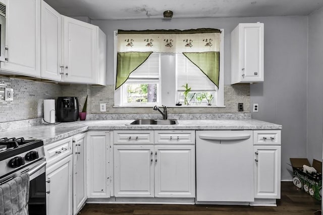 kitchen featuring dishwasher, white cabinetry, a sink, and light countertops