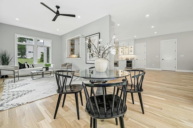 dining room with ceiling fan, light wood-type flooring, and wine cooler