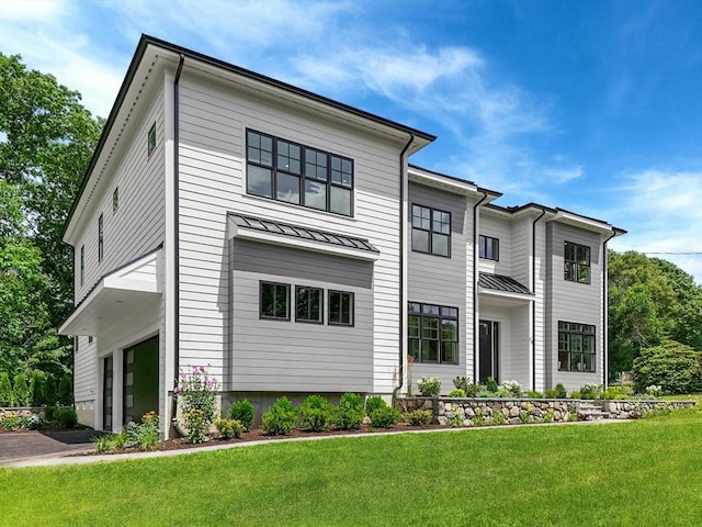 view of front of property featuring a front yard and a garage