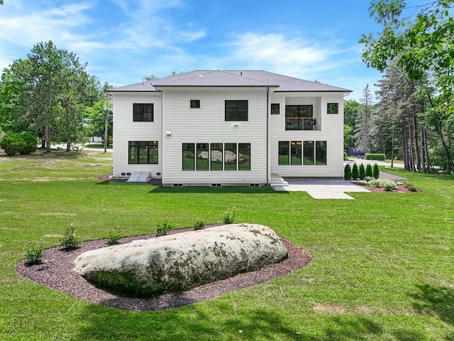 back of house with a lawn and a patio area