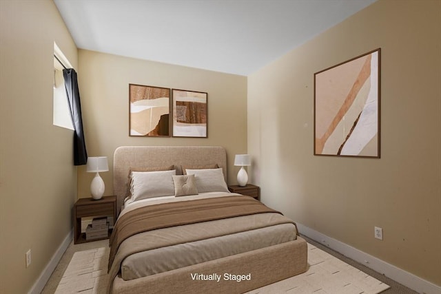 bedroom with light colored carpet and baseboards