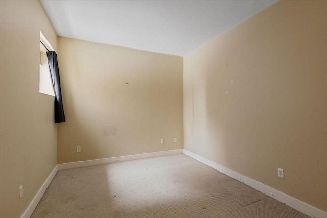 empty room with light colored carpet and baseboards