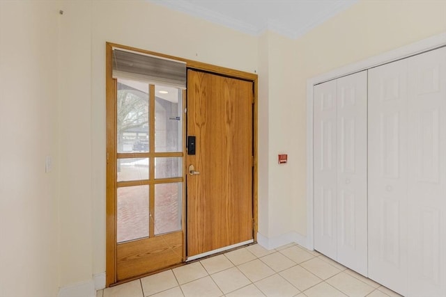 entryway featuring crown molding, baseboards, and light tile patterned floors