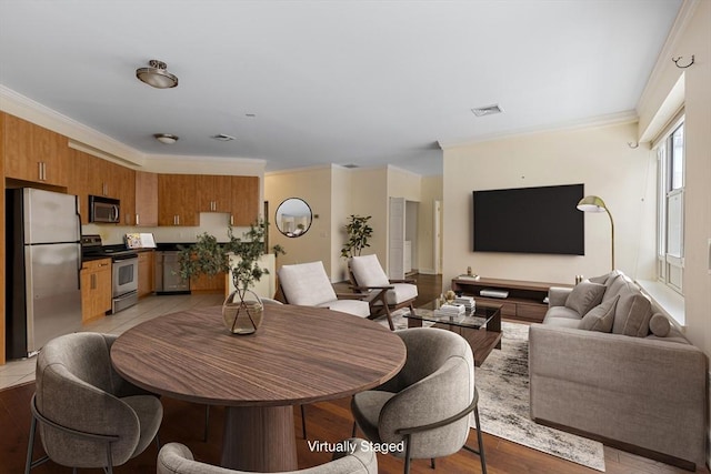 dining space with ornamental molding and visible vents