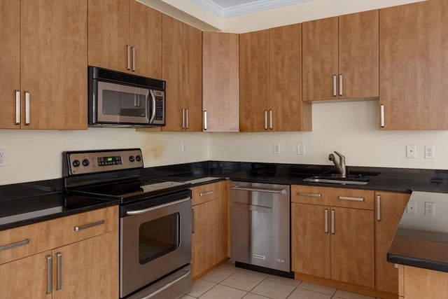 kitchen featuring crown molding, stainless steel appliances, light tile patterned flooring, a sink, and dark stone counters