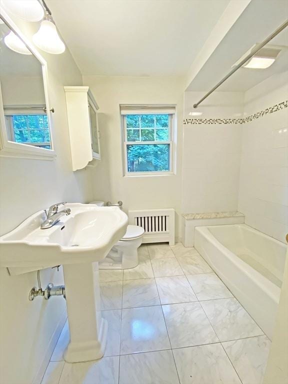 bathroom with  shower combination, radiator heating unit, marble finish floor, and toilet