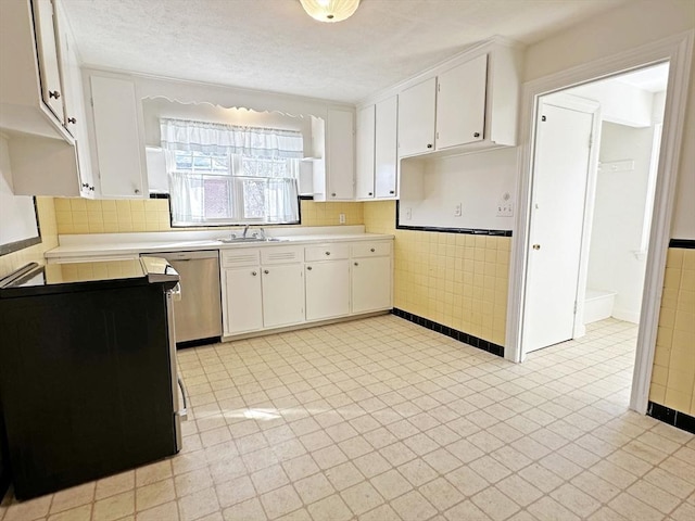 kitchen featuring white cabinets, a sink, light countertops, and stainless steel dishwasher