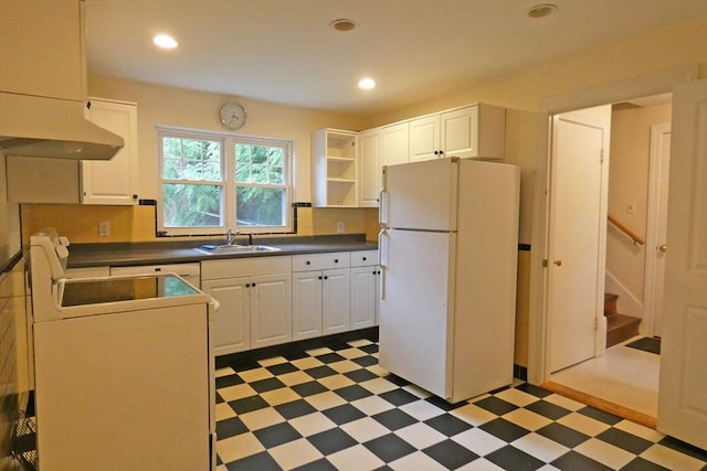 kitchen featuring dark countertops, light floors, a sink, and freestanding refrigerator