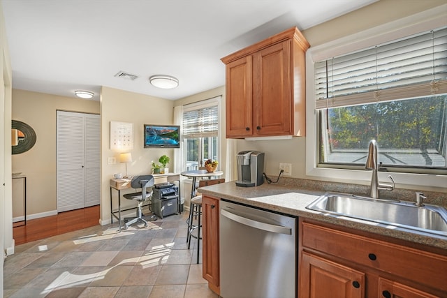 kitchen featuring light tile patterned floors, dishwasher, and sink