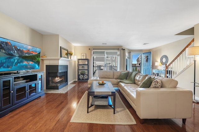 living room with hardwood / wood-style flooring and a multi sided fireplace