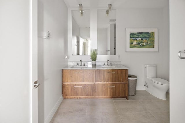 bathroom with tile patterned flooring, double vanity, toilet, and a sink