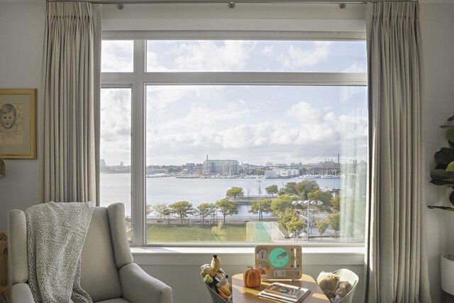 sitting room with plenty of natural light, a city view, and a water view