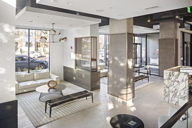 living room with a wall of windows, plenty of natural light, and visible vents