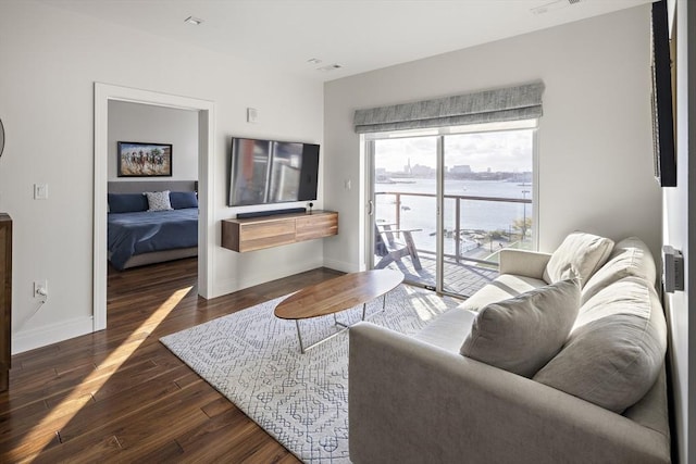 living area with baseboards and wood finished floors