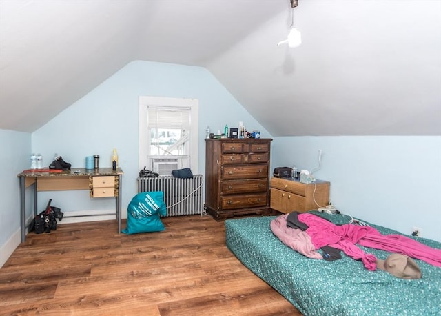 bedroom featuring radiator, cooling unit, wood finished floors, and lofted ceiling